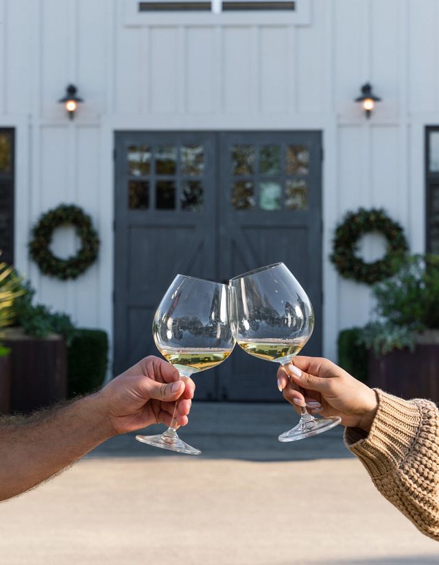 Two hands holding white wine