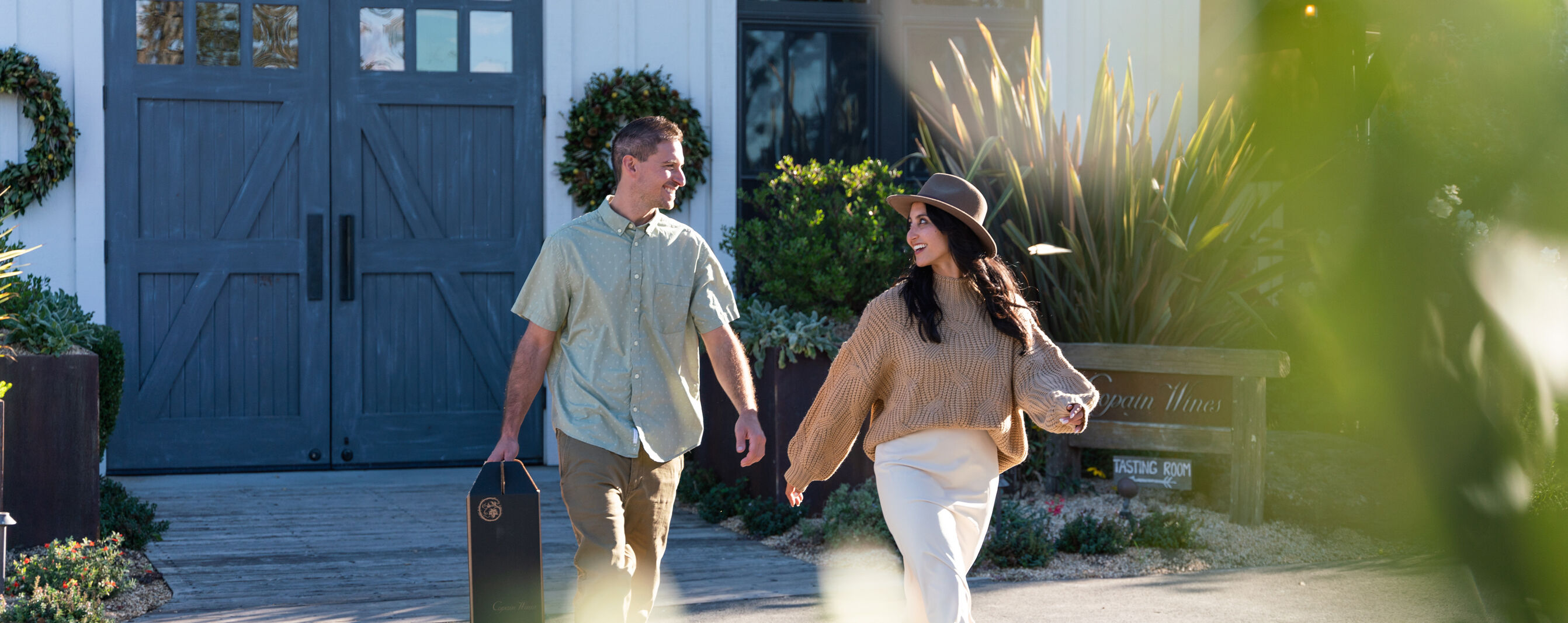 A couple walking out of the Copain Estate with their club wines.