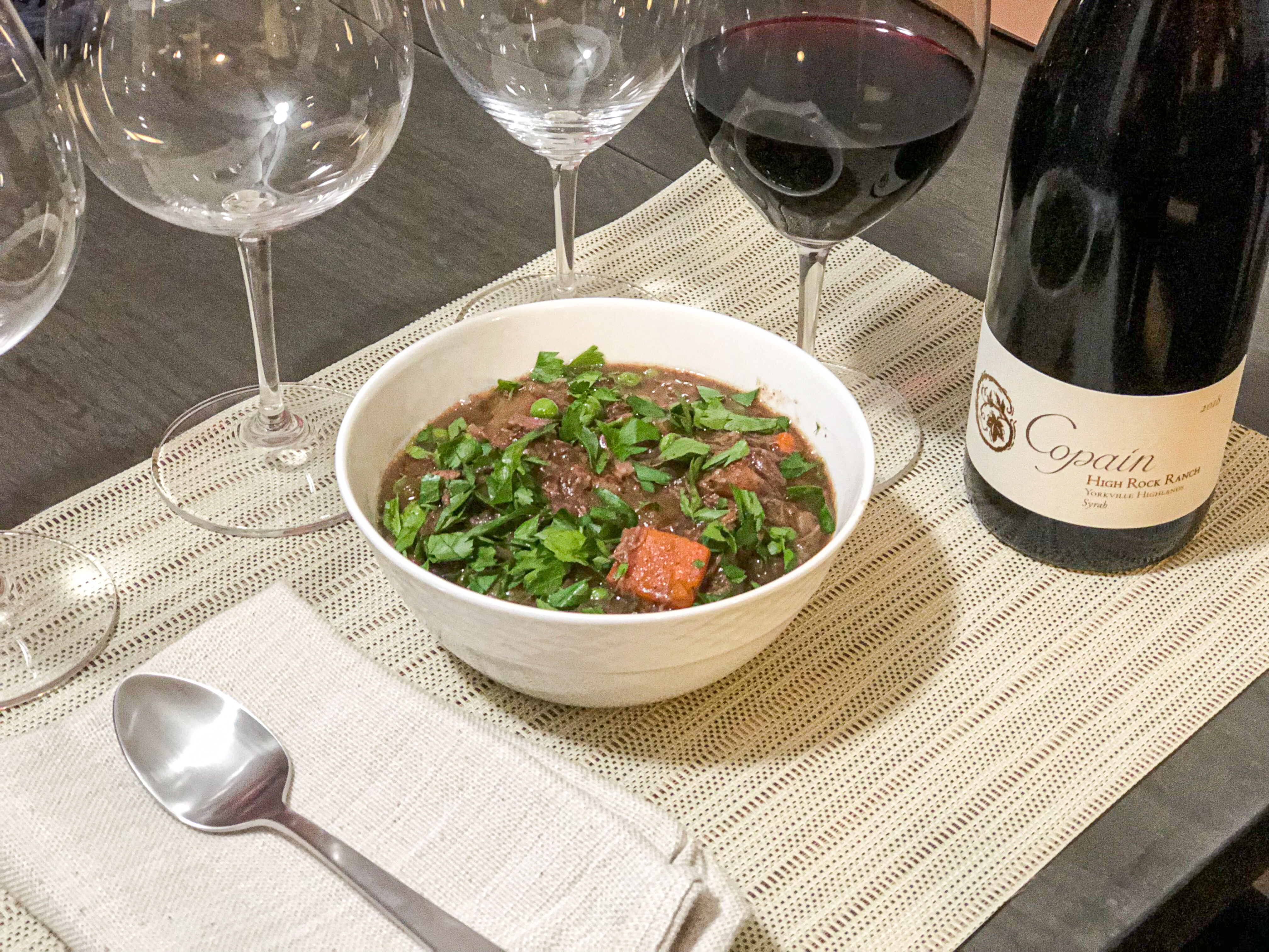 A place setting of a bowl of Boeuf Bourguignon. A place setting of a bowl of Boeuf Bourguignon.