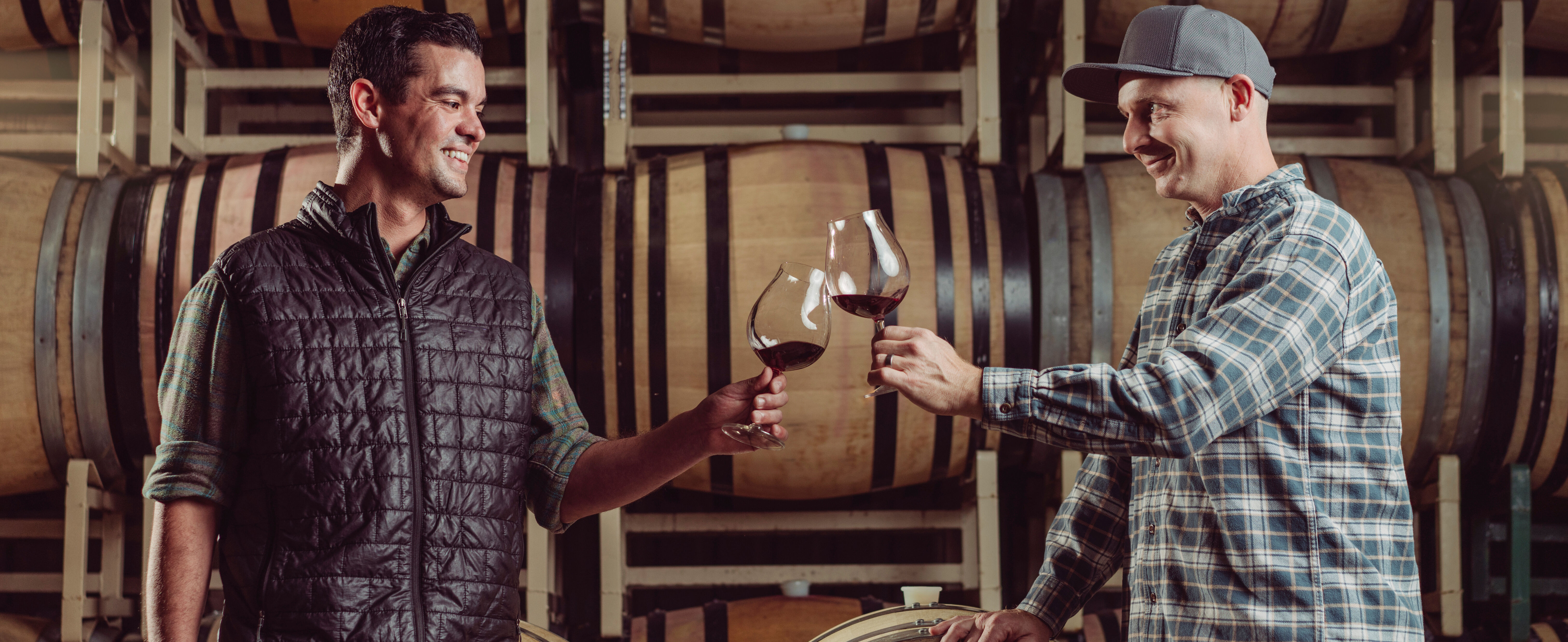 Copain winemaker, Ryan Zepaltas, cheersing over a wine barrel.