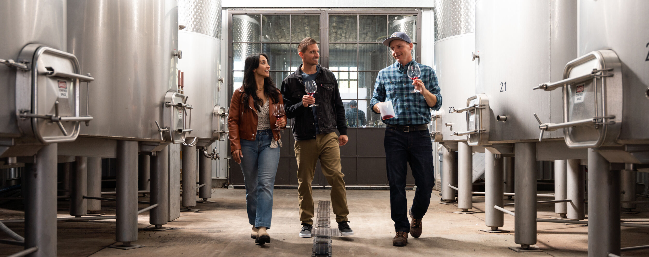 Copain winemaker, Ryan Zepaltas, walking in Copain winery with two guests. Copain winemaker, Ryan Zepaltas, walking in Copain winery with two guests.